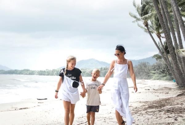 Mother walking and holding hands with her children on the beach at Palm Cove, Cairns, Queensland © Tourism and Events Queensland
