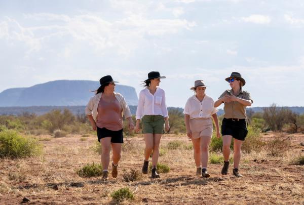 A group of three women walking together with a SEIT Outback Tours guide, Outback Australia, Northern Territory © Tourism Australia